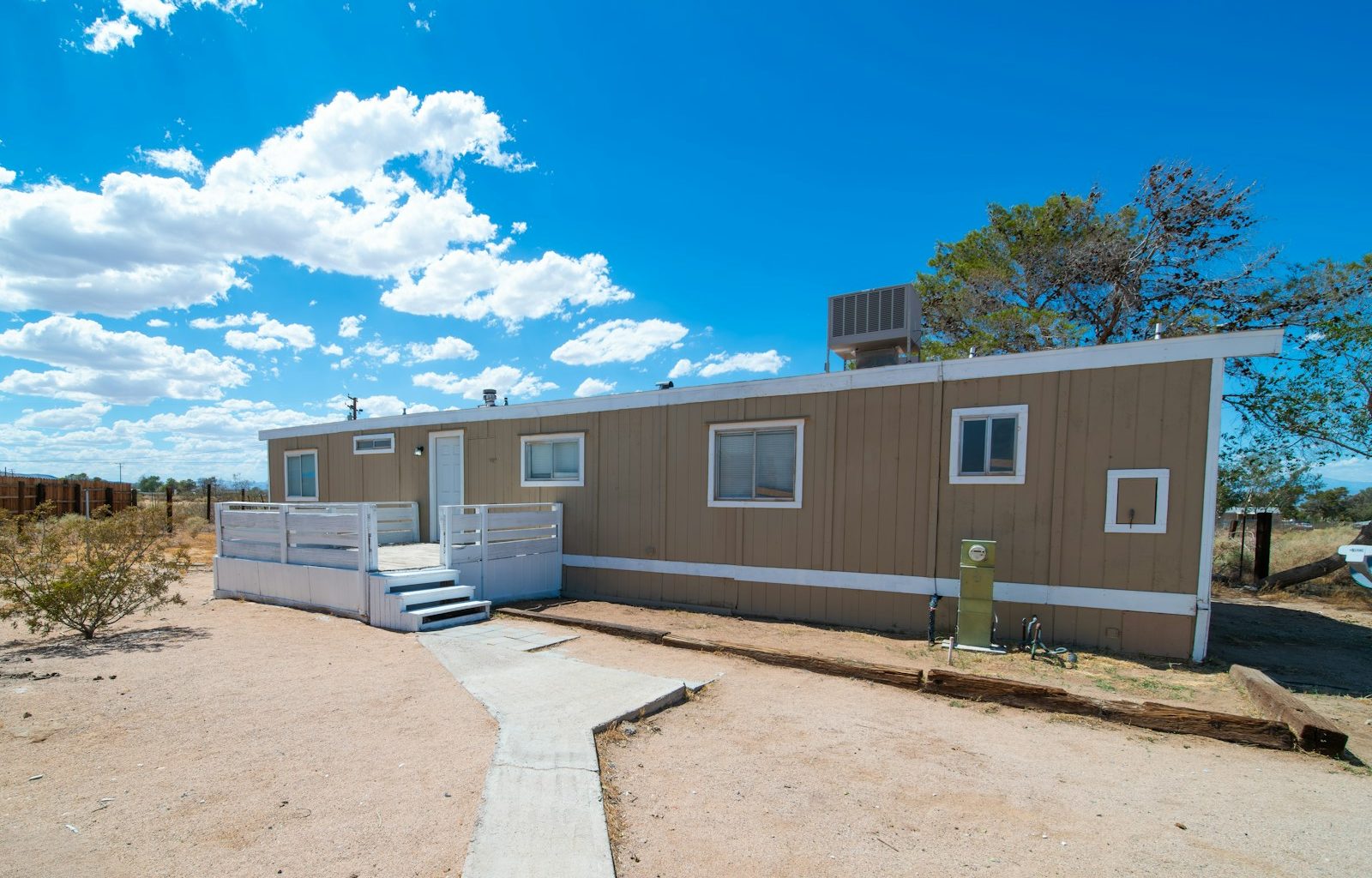 a couple of small houses sitting on top of a dirt field