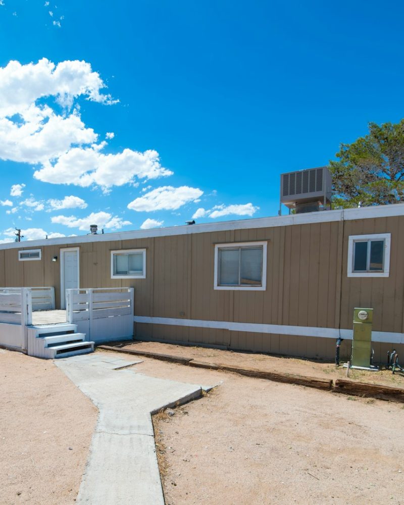 a couple of small houses sitting on top of a dirt field