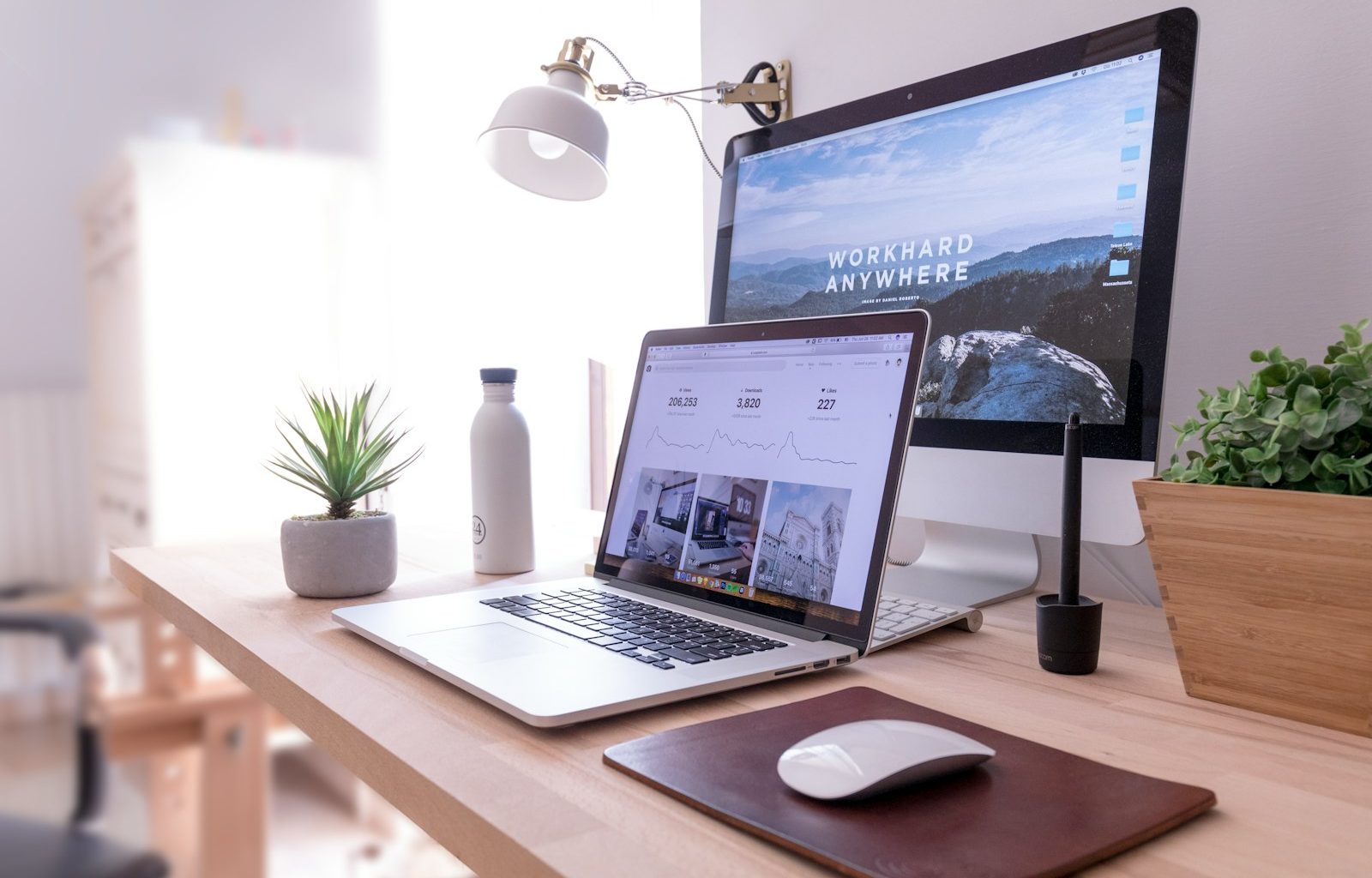 MacBook Pro on table beside white iMac and Magic Mouse