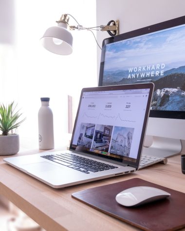 MacBook Pro on table beside white iMac and Magic Mouse