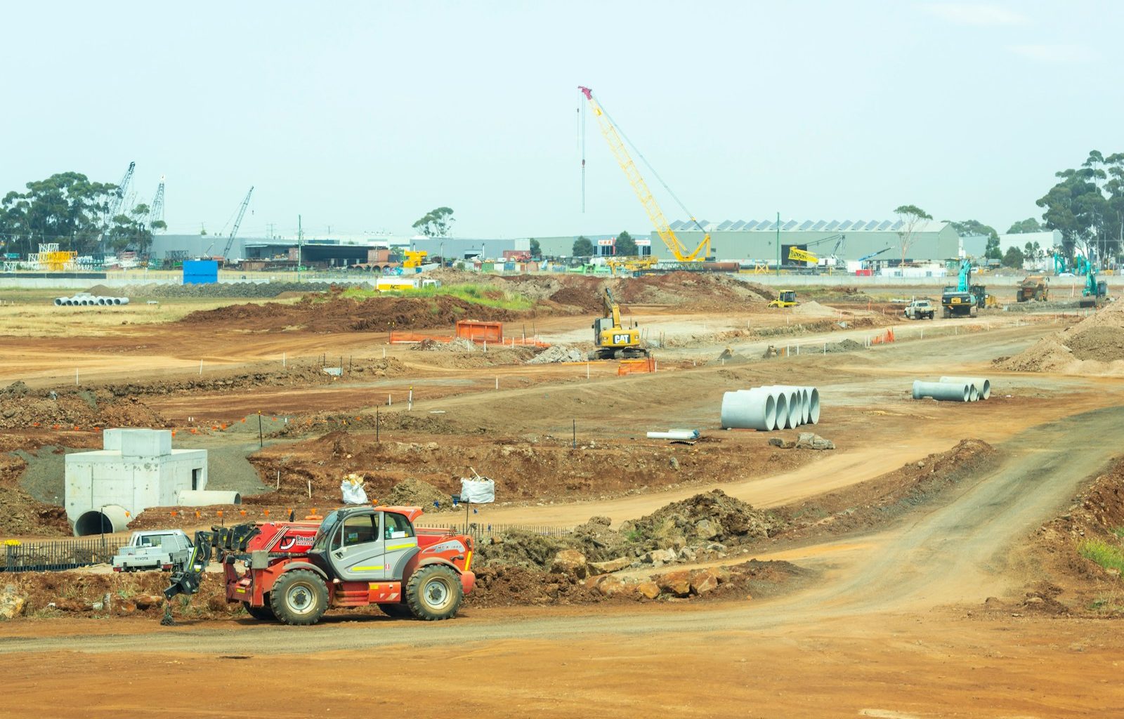 orange and white heavy equipment on muddy road during daytime