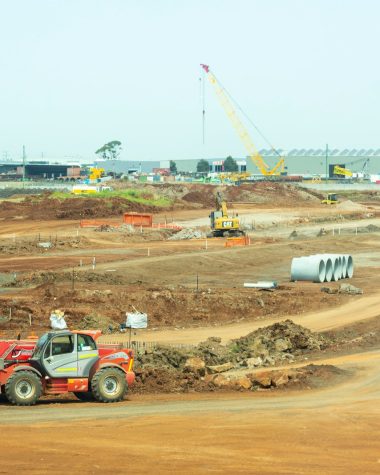 orange and white heavy equipment on muddy road during daytime