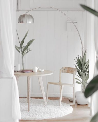 white steel chair in front round table on white rug