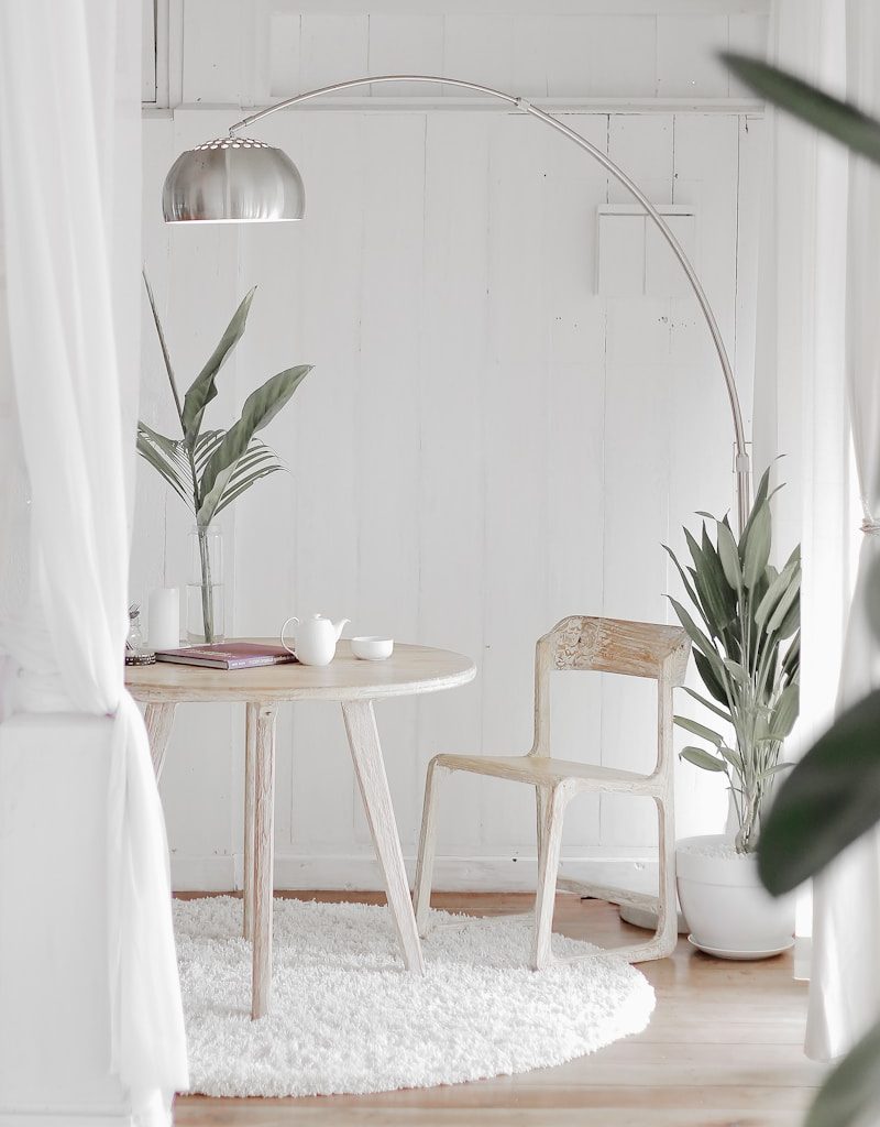 white steel chair in front round table on white rug