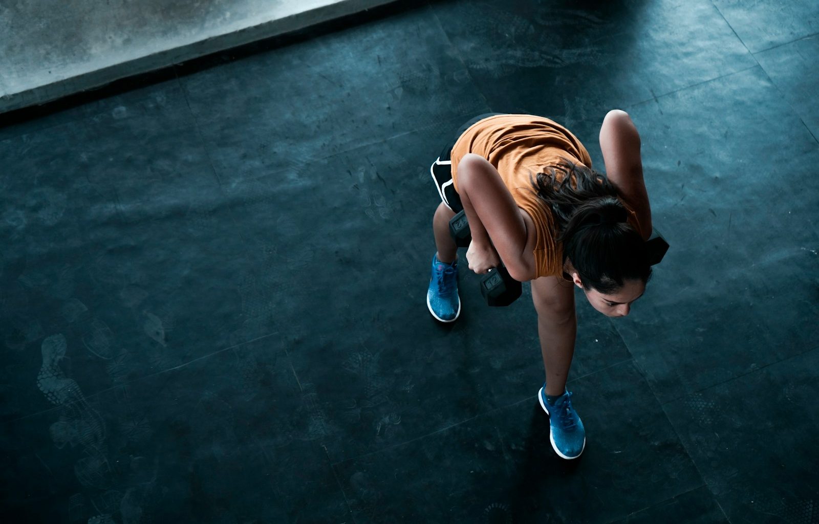 woman in orange top exercising indoors