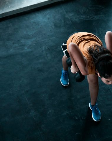 woman in orange top exercising indoors