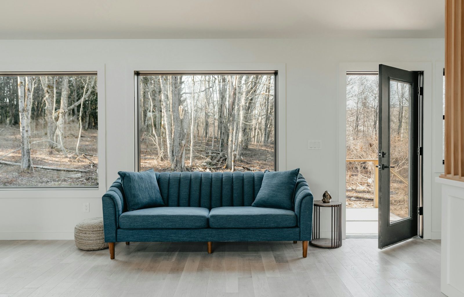 a blue couch sitting in a living room next to two windows