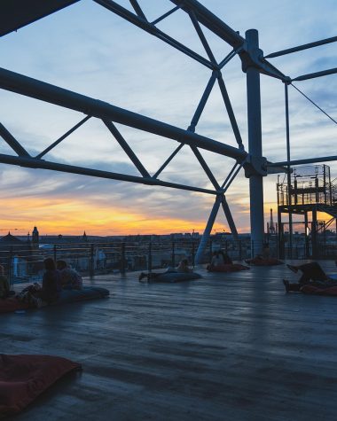 Sfeervol verlicht terras met snoerverlichting boven een tuintafel op een zomerse avond