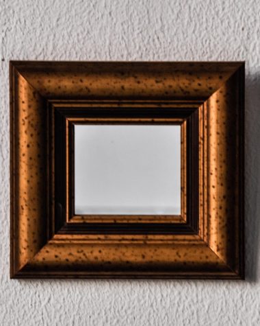 Stijlvolle hal met wanddecoratie, een ronde spiegel en een donkere accentwand