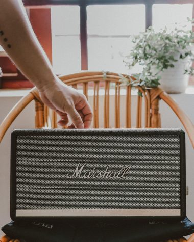 Waterdichte Bluetooth-speaker op een houten tuintafel in de zomerse buitenlucht