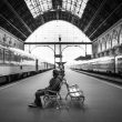 Persoon met over-ear koptelefoon in een volle trein, werkend op laptop